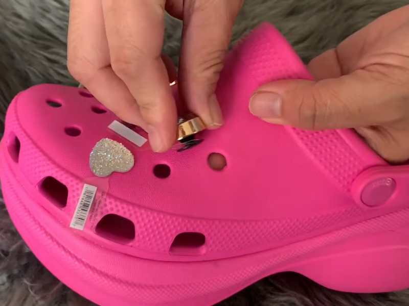 Gently pull out the Jibbitz charm by squeezing the top of your Crocs. 